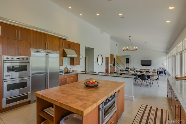 10630 Garr Rd, Berrien Springs, MI 49103 - kitchen with appliances with stainless steel finishes, a warming drawer, under cabinet range hood, brown cabinetry, and butcher block counters