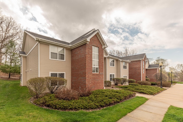 1005 E Duncan St Unit 2D, Manchester, MI 48158 - view of side of property with a lawn and brick siding
