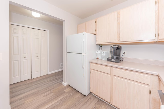 1005 E Duncan St Unit 2D, Manchester, MI 48158 - kitchen featuring light brown cabinetry, light countertops, light wood-style flooring, baseboards, and freestanding refrigerator