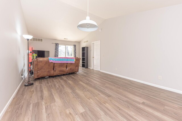 1005 E Duncan St Unit 2D, Manchester, MI 48158 - living area with wood finished floors, baseboards, vaulted ceiling, and visible vents
