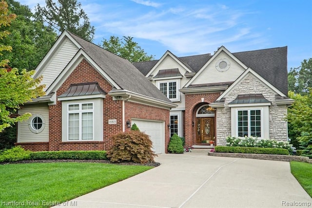 view of front of property with concrete driveway, a front lawn, a standing seam roof, and stone siding
