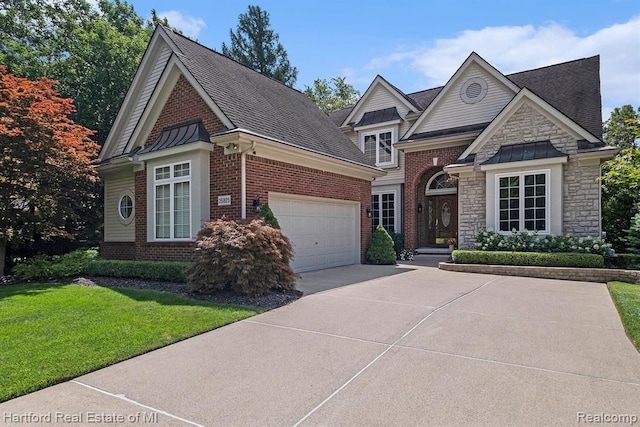 traditional home with concrete driveway, a front lawn, stone siding, brick siding, and roof with shingles