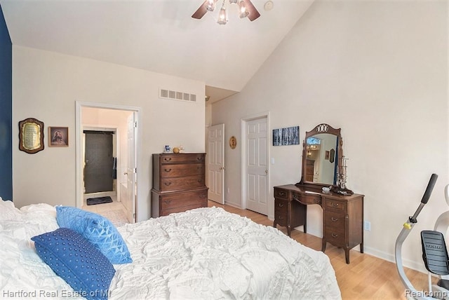 bedroom with visible vents, a ceiling fan, light wood-style floors, baseboards, and high vaulted ceiling