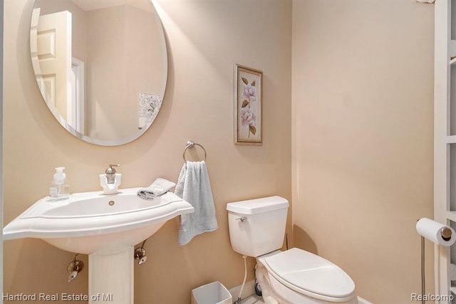 bathroom with baseboards and toilet