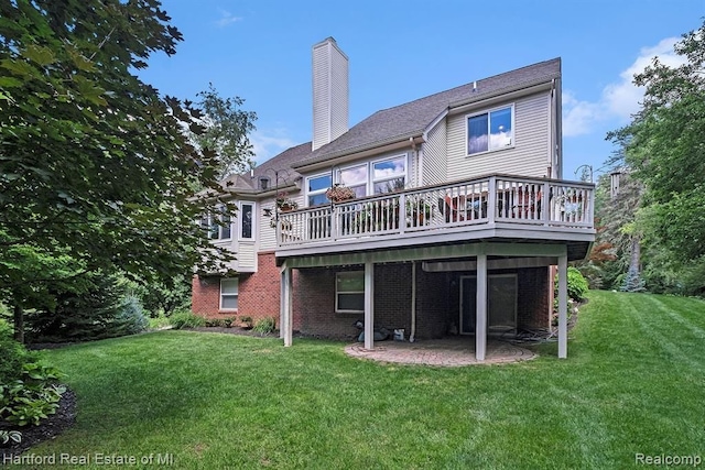 rear view of house featuring a lawn, a chimney, brick siding, and a wooden deck