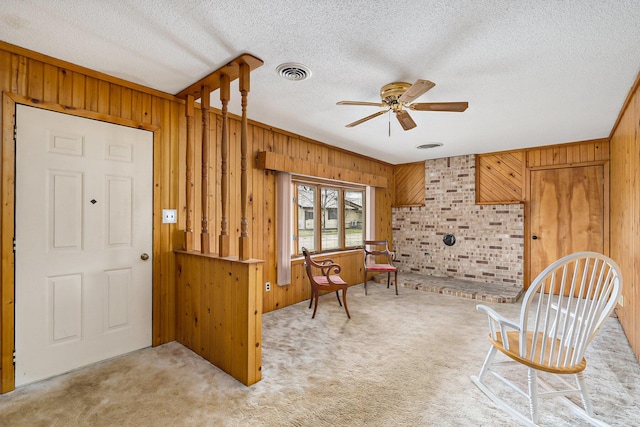4302 Lake Dr, Beaverton, MI 48612 - living area with wooden walls, visible vents, a textured ceiling, and ceiling fan