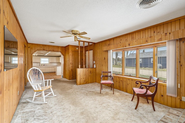 4302 Lake Dr, Beaverton, MI 48612 - sitting room with wood walls, a ceiling fan, a textured ceiling, and visible vents