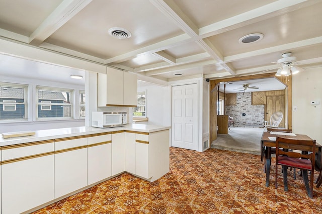 4302 Lake Dr, Beaverton, MI 48612 - kitchen featuring beam ceiling, visible vents, white microwave, coffered ceiling, and a ceiling fan