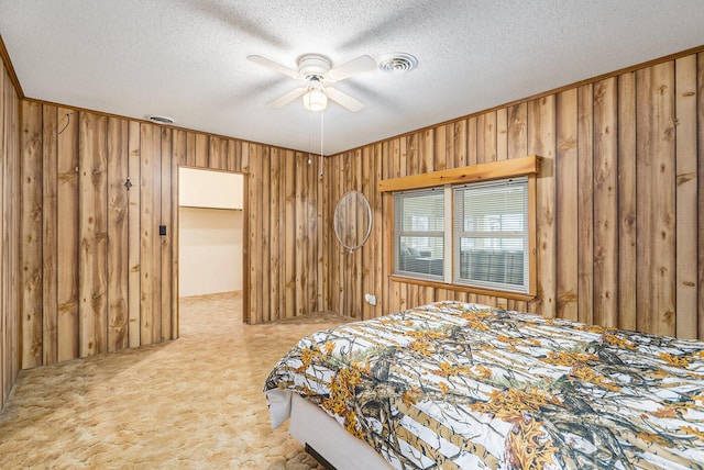 4302 Lake Dr, Beaverton, MI 48612 - bedroom featuring a textured ceiling, visible vents, light colored carpet, a ceiling fan, and wood walls