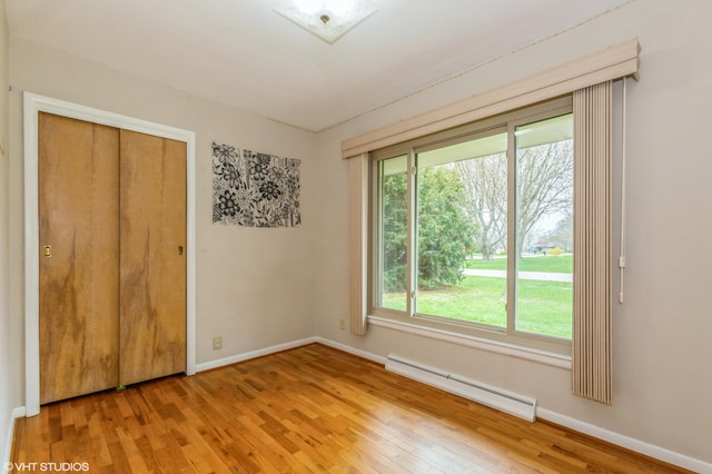 3105 Kevin St, Saint Joseph, MI 49085 - unfurnished bedroom featuring baseboards, wood finished floors, baseboard heating, and multiple windows