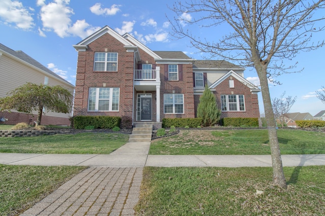 view of front of property with brick siding, a balcony, and a front yard