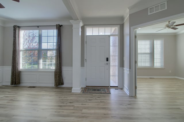 entrance foyer featuring visible vents, ornamental molding, ceiling fan, and wood finished floors