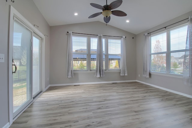 unfurnished room with a ceiling fan, baseboards, vaulted ceiling, and light wood-type flooring