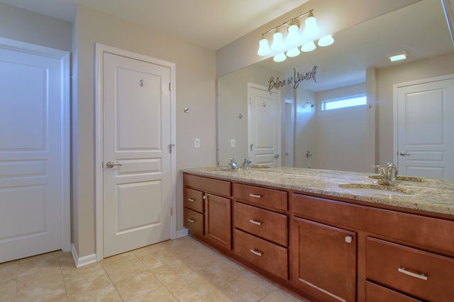 bathroom featuring tile patterned floors, baseboards, double vanity, and a sink