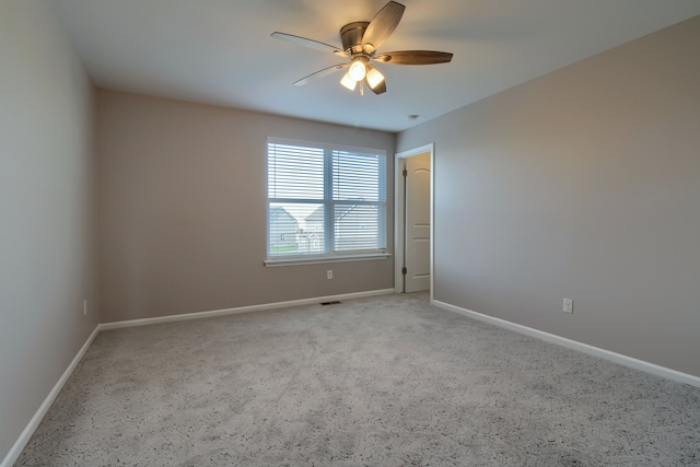 empty room featuring a ceiling fan, light carpet, and baseboards