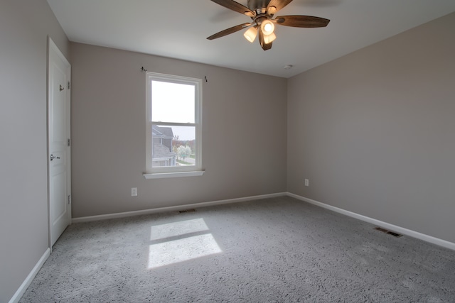 spare room featuring baseboards, visible vents, and ceiling fan
