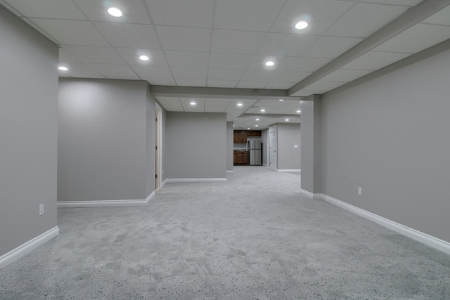 basement featuring light colored carpet, recessed lighting, freestanding refrigerator, and baseboards