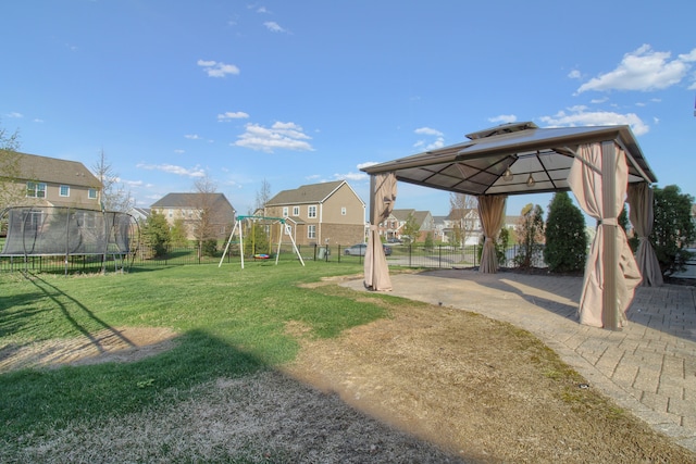 view of yard with a residential view, a playground, a trampoline, a gazebo, and fence