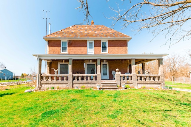 view of front facade with a front lawn, covered porch, and brick siding