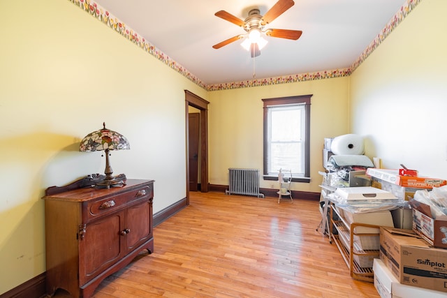 interior space featuring radiator, ceiling fan, baseboards, and light wood-type flooring