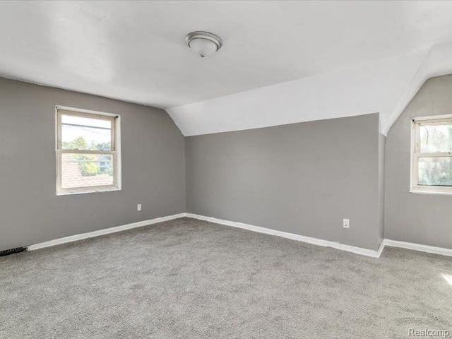 bonus room with vaulted ceiling, carpet floors, and baseboards