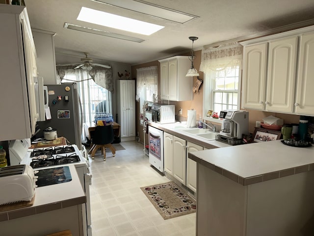 326 Basket Br, Oxford, MI 48371 - kitchen with light floors, a sink, white appliances, a peninsula, and hanging light fixtures
