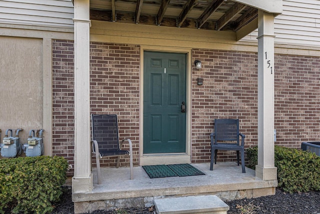entrance to property featuring brick siding
