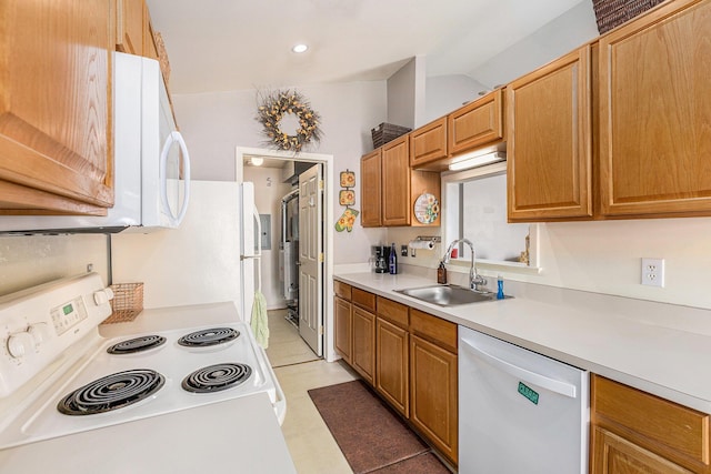 kitchen with a sink, white appliances, and light countertops