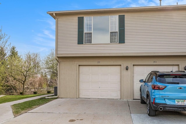 garage with driveway and fence