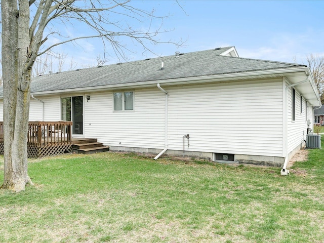 back of property with cooling unit, a deck, a yard, and a shingled roof