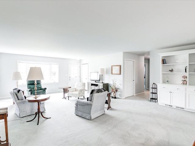 living room featuring baseboards and light colored carpet