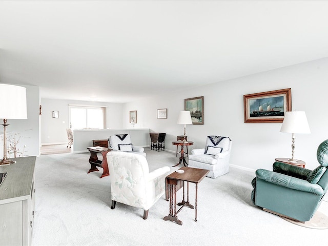 living area featuring carpet flooring and baseboards