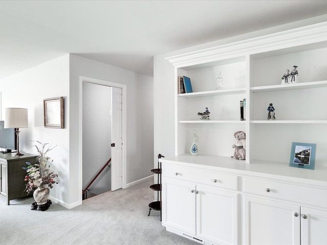 hall featuring an upstairs landing, visible vents, light colored carpet, and baseboards