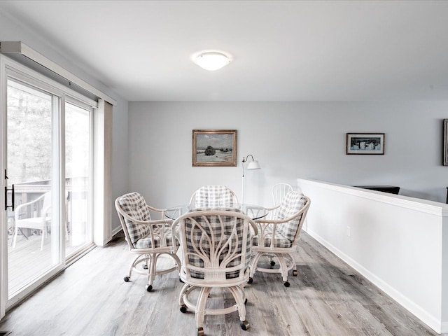 dining space with baseboards and wood finished floors