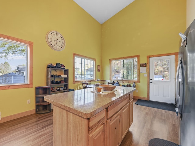kitchen featuring light countertops, light wood finished floors, and high vaulted ceiling