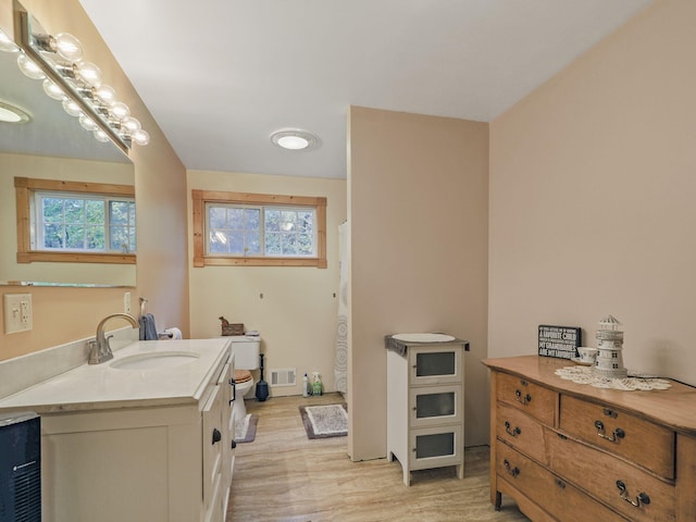 full bath with toilet, visible vents, wood finished floors, a shower with shower curtain, and vanity