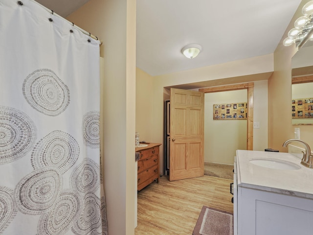 bathroom with a shower with shower curtain, vanity, and wood finished floors