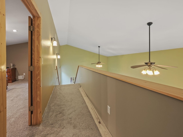 corridor with vaulted ceiling, an upstairs landing, baseboards, carpet flooring, and visible vents