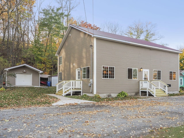 view of front of home featuring an outdoor structure, a detached garage, and metal roof