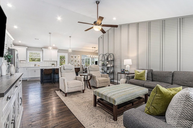 living area with recessed lighting, dark wood-style flooring, ceiling fan with notable chandelier, and lofted ceiling