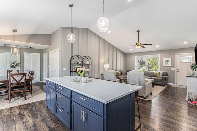 kitchen featuring a center island, a ceiling fan, vaulted ceiling, dark wood-style floors, and blue cabinets