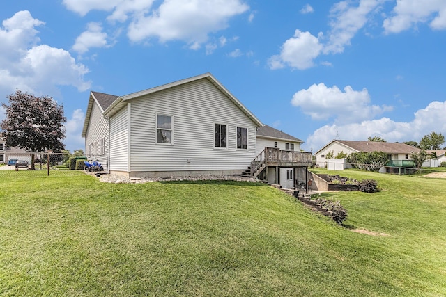 rear view of house featuring fence, a yard, stairway, and a deck