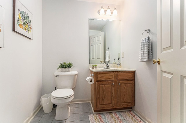 half bathroom featuring toilet, tile patterned floors, baseboards, and vanity