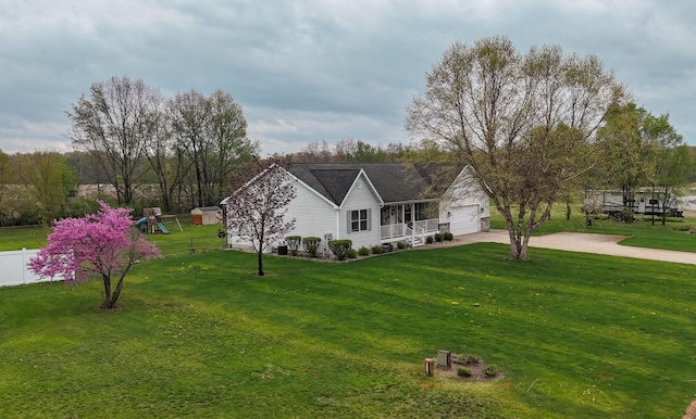 view of front of property featuring fence, a front lawn, a garage, a porch, and concrete driveway