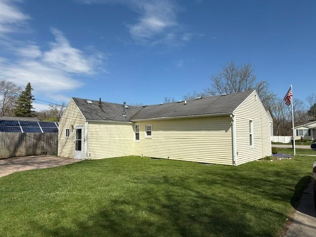 back of property featuring a yard, a patio area, and fence
