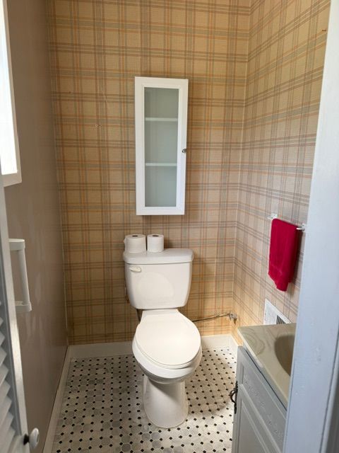bathroom featuring tile patterned flooring, vanity, toilet, and baseboards