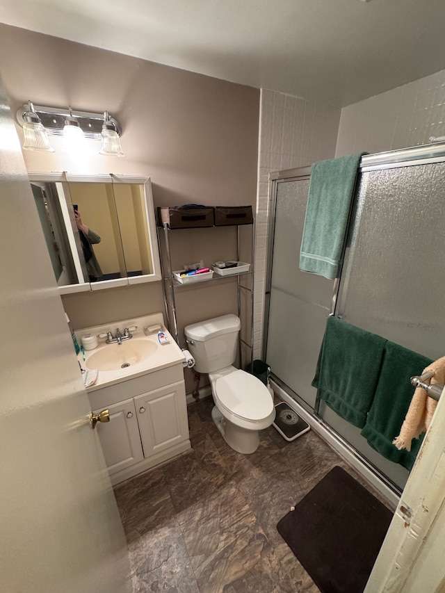 full bathroom featuring a stall shower, vanity, and toilet