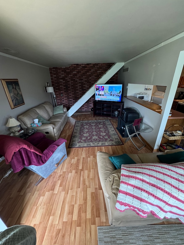 living room featuring visible vents, crown molding, and wood finished floors