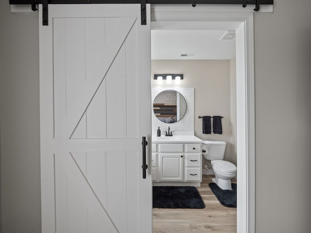 41698 Brownstone Dr, Novi, MI 48377 - bathroom with visible vents, wood finished floors, vanity, and toilet