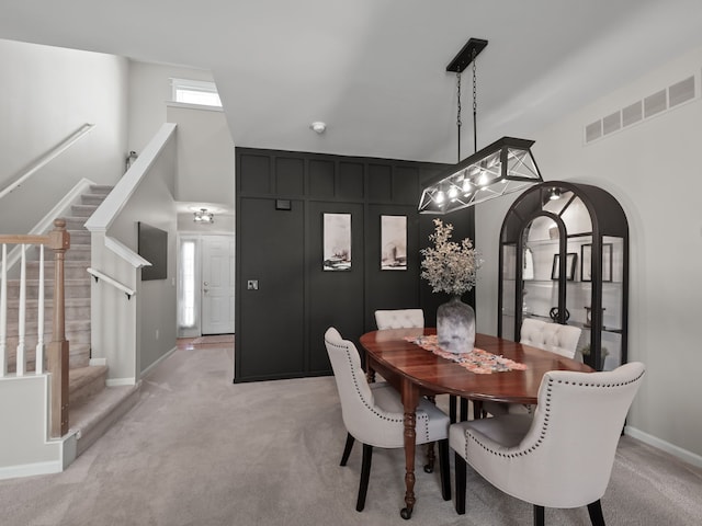 41698 Brownstone Dr, Novi, MI 48377 - dining area featuring arched walkways, stairway, visible vents, and light carpet